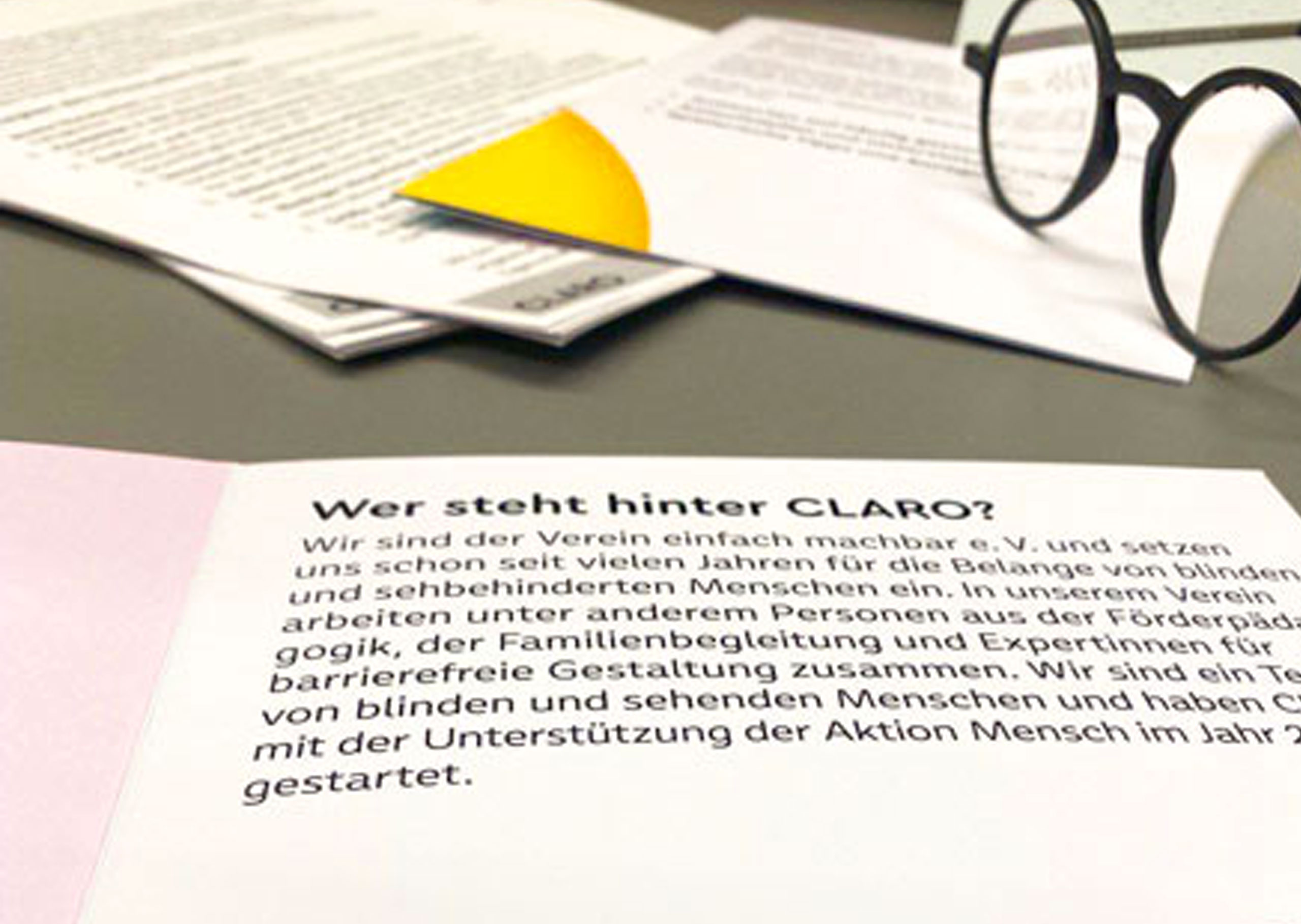 Infoflyer zum Projekt CLARO liegt aufgeschlagen auf einem Tisch.