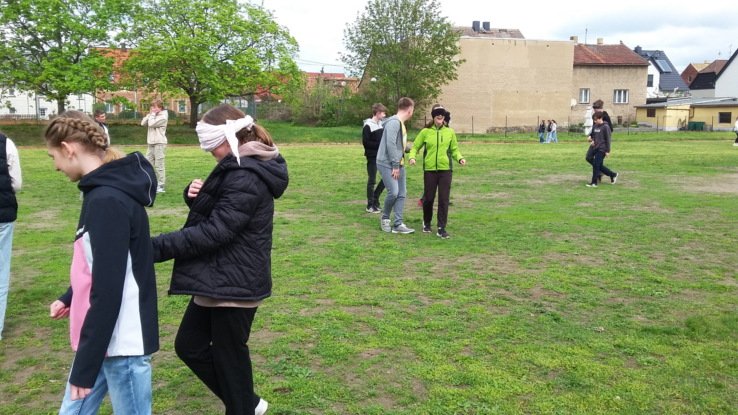 Mobilitätstraining auf dem Sportplatz: Die Jugendlichen führen sich gegenseitig.